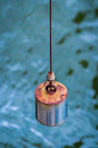 Close-up of rusty metal hanging against water