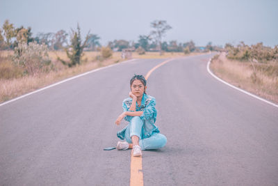 Portrait of woman sitting on road