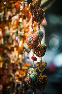 Close-up of decorations hanging in market for sale