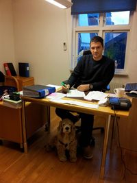 Portrait of businessman with dog working in office