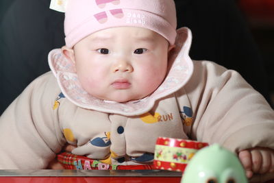 Portrait of cute baby boy sitting on soft at home