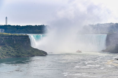 Panorama of the canadian side of the falls, with a tourist boat. . niagara falls,