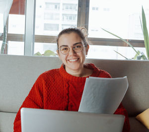 Portrait of young woman using laptop at home