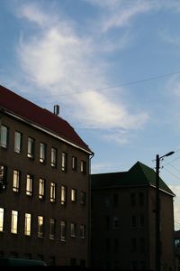 Low angle view of buildings against cloudy sky