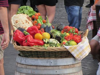 Low section of people by vegetables in basket for sale at market