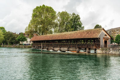 Houses by lake against sky