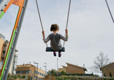 Low angle view of swing at playground against sky