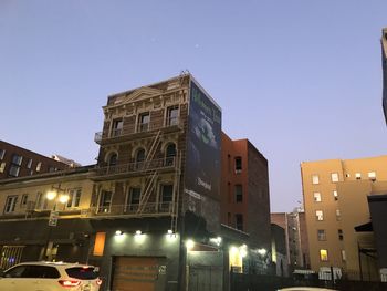Low angle view of illuminated buildings against clear sky at night