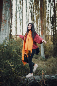 Portrait of young woman standing in forest