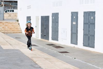 Full length of young woman walking on street