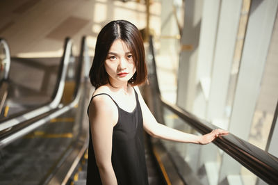 Portrait of woman standing on escalator