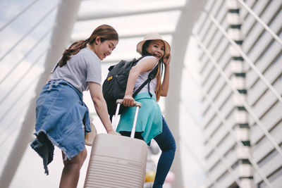 Tourist with luggage on steps in city