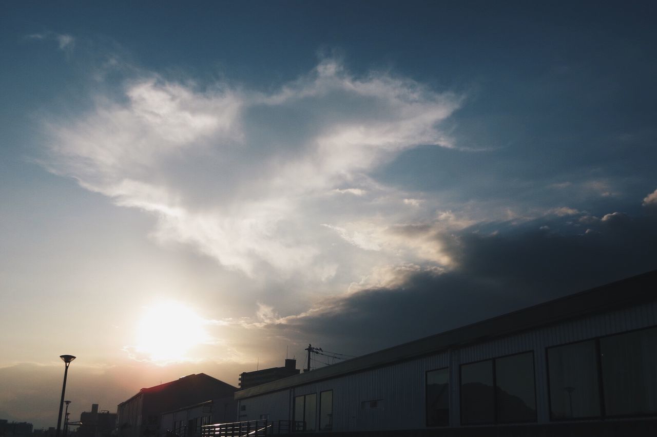 architecture, built structure, building exterior, sky, low angle view, cloud, cloud - sky, sun, outdoors, day, high section, no people, bright, city life, exterior