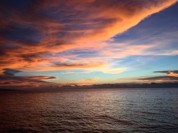 Scenic view of sea against dramatic sky during sunset