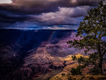View of rock formations on landscape against cloudy sky