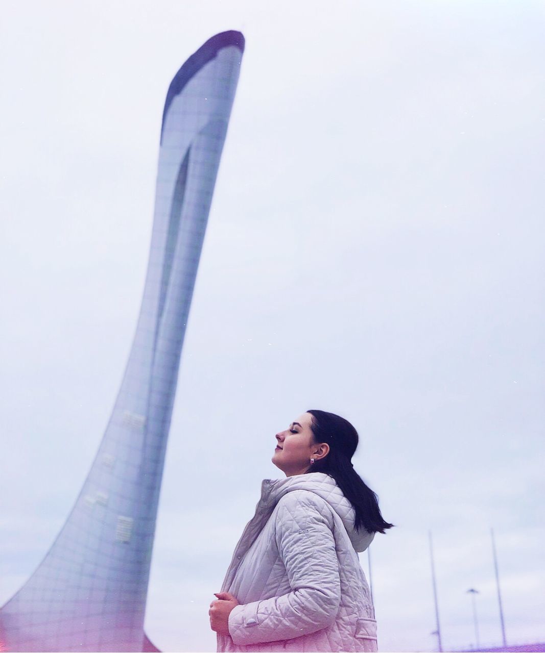 LOW ANGLE VIEW OF YOUNG WOMAN AGAINST SKY