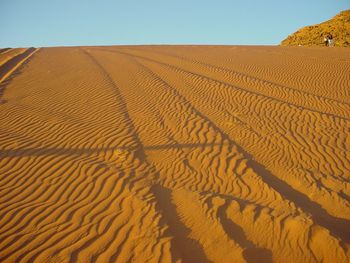 Sand dune in desert against clear sky