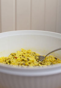 Caribbean rice in a white serving container with a silver serving spoon