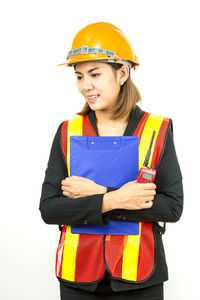 Smiling young woman standing against white background