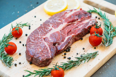 High angle view of meat with ingredients on cutting board