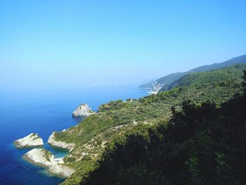 Cliff by sea at skopelos against clear sky