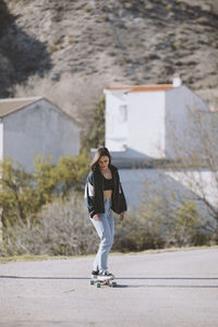 Full length of boy standing on road against building