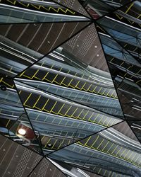 Low angle view of escalators reflecting on modern ceiling