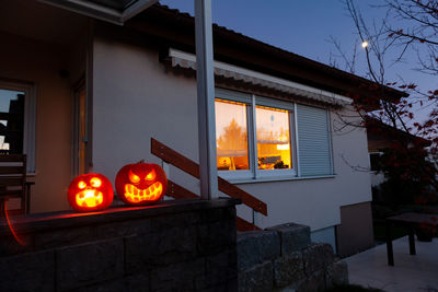 Illuminated pumpkin outside house at night