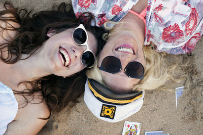 Overhead view of cheerful friends lying at beach