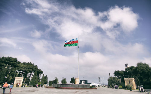 Flag by street against sky in city