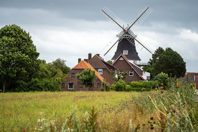 Traditional windmill on field against sky