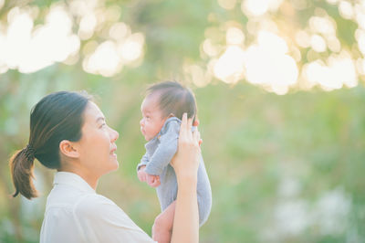 Side view of mother and daughter outdoors