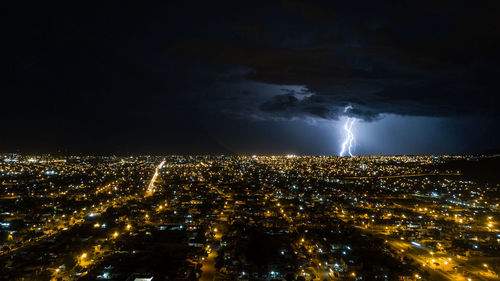 Aerial view of illuminated city against sky at night