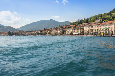 Scenic view of sea by buildings against sky