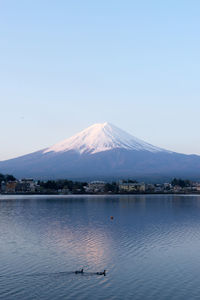 Scenic view of lake and snowcapped fuji mountains against sky