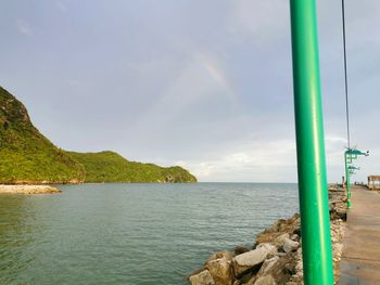 Scenic view of sea against rainbow in sky