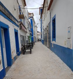 Empty road against buildings