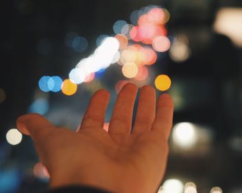 Close-up of hand on illuminated blurred background