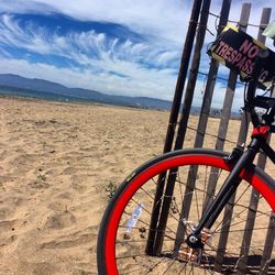 Bicycle on sand against sky