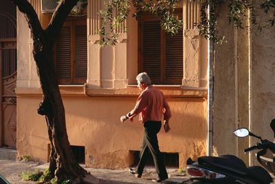 Full length of woman walking by building