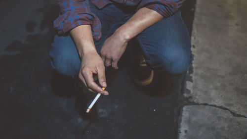 Low section of man smoking cigarette