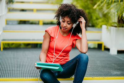 Young man using mobile phone while sitting on bench