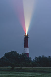 Germany, schleswig-holstein, pellworm, pellworm lighthouse casting colorful light at dusk