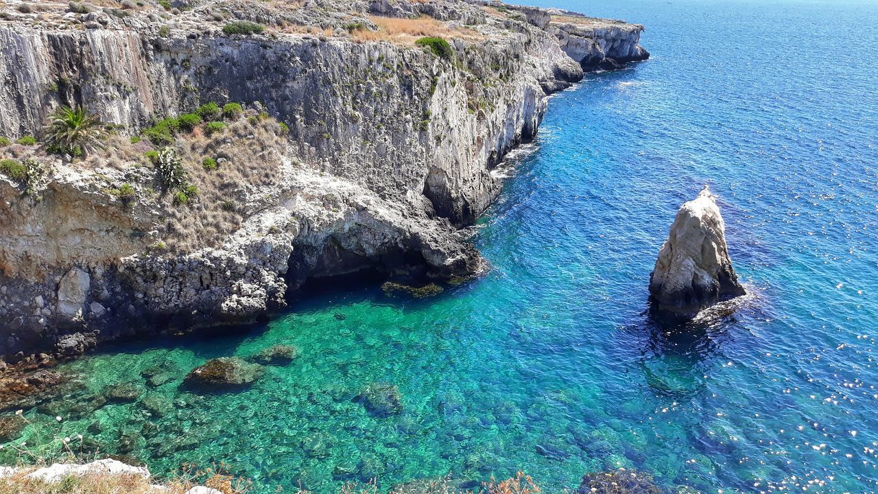 HIGH ANGLE VIEW OF ROCKS ON SEA SHORE