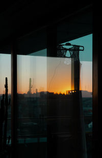 Digital composite image of buildings against sky seen through glass window