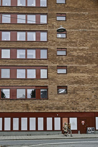 People walking on street by building in city