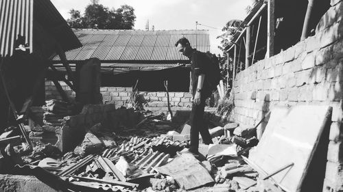 Man standing by demolished house