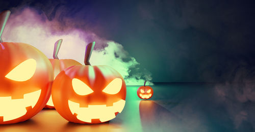 Close-up of illuminated pumpkin against sky during halloween