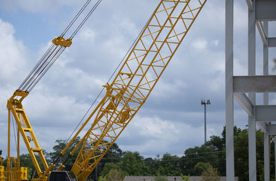 Low angle view of cranes against sky