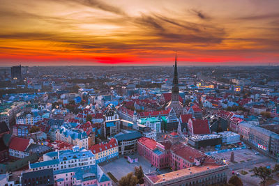 High angle view of city against cloudy sky during sunset